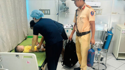 Trung tá Ngô Văn Quỳnh hỗ trợ đưa cháu bé bị co giật vào bệnh viện cấp cứu.