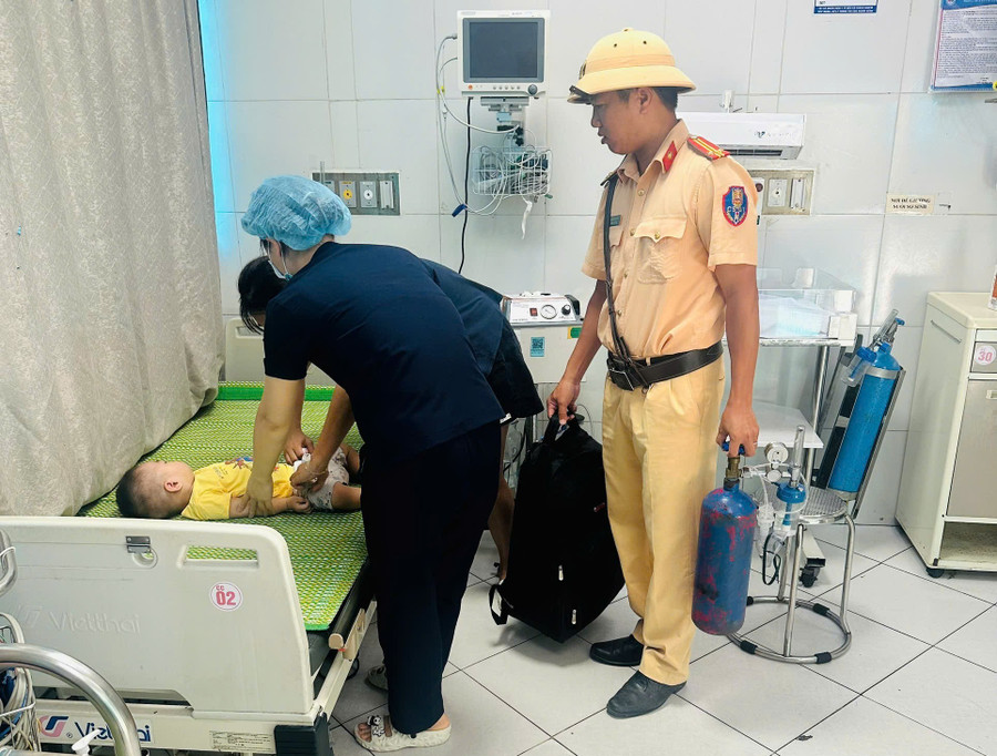 Trung tá Ngô Văn Quỳnh hỗ trợ đưa cháu bé bị co giật vào bệnh viện cấp cứu.